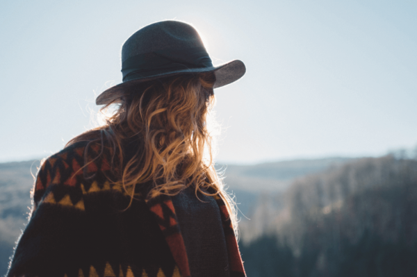 Kvinde med hat foran landskab