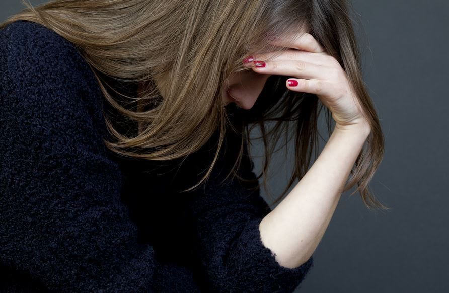 Bekymret kvinde tager sig til hovedet, træt af problemløsning