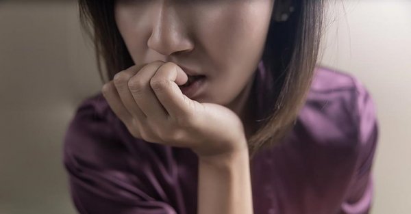 Kvinde med blandet angst-depressionstilstand bider negle
