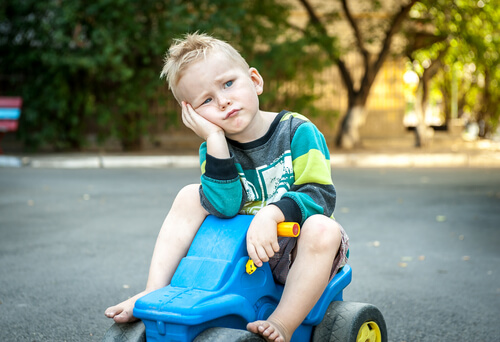 Trist dreng på legetøjsbil oplever rigt barn syndrom