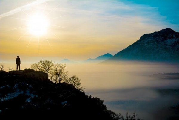 Mand på toppen af bjerg er igang med mindfulness