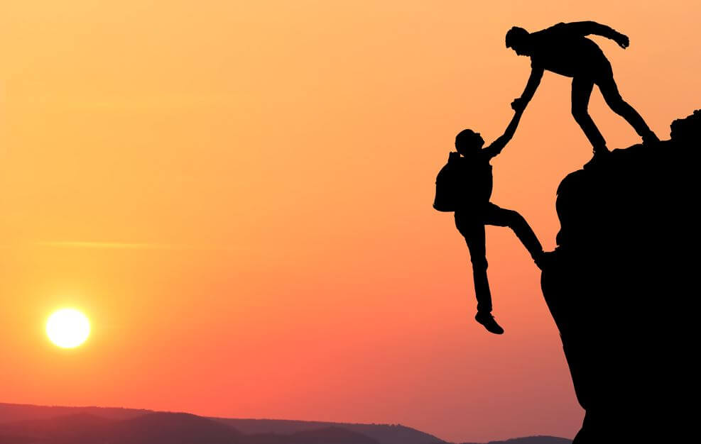 Venner hjælper hinanden op på bjerg, da tillid gør man sig fortjent til