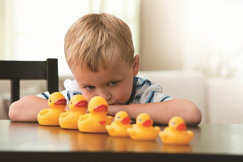 Dreng med autisme arrangerer legetøj