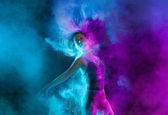 Kvinde danser i blå og lilla farver. Gør en indsats