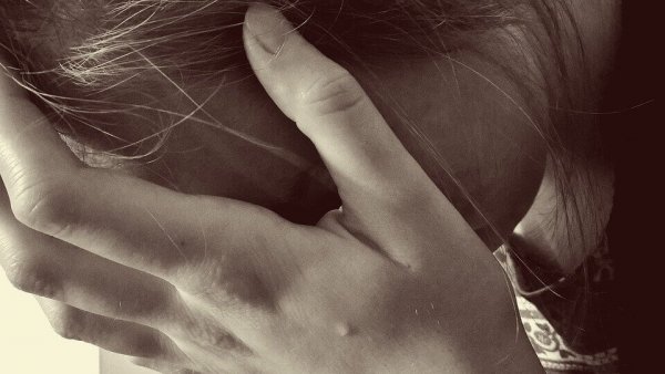 Kvinde fyldt med misundelse græder med hovedet i hænderne
