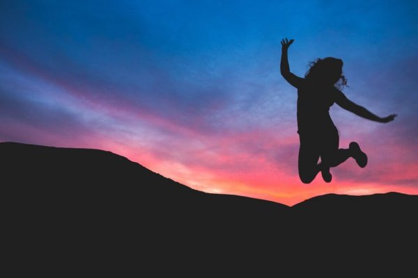 Person hopper over bjerge og føler sig styrket af empowerment