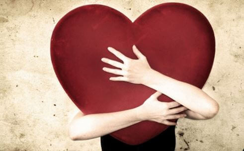 Person krammer hjerte som symbol på følelsesmæssig afhængighed