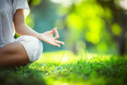 Kvinde mediterer i natur for at skabe en kilde til positive følelser