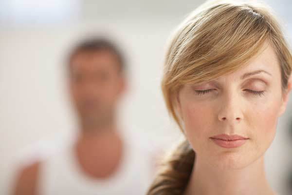 Rolig kvinde med lukkede øjne udøver mental kontrol