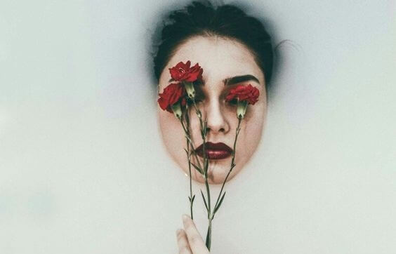 Kvinde med roser foran øjne som symbol for følelsesmæssige tømmermænd