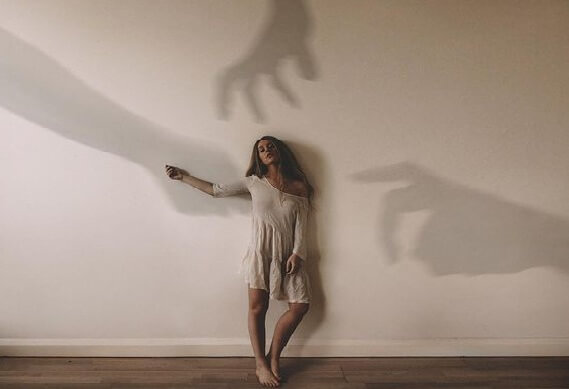 Kvinde på væg med hænders skygger