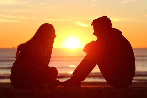 Par sidder og snakker foran solopgang