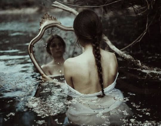 Kvinde i flod med stort spejl