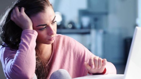 Kvinde ved bord er trist over passiv vold