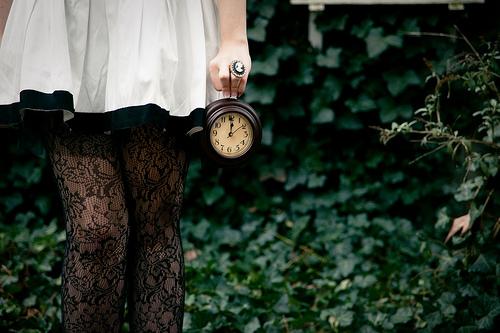 Kvinde står med gammelt ur