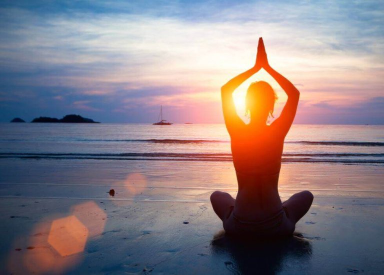 Person dyrker yoga på strand