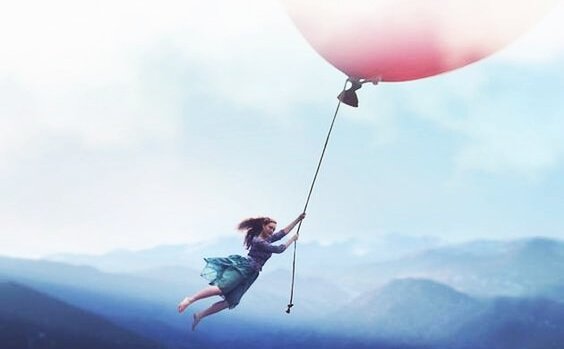 Pige flyver med kæmpe ballon