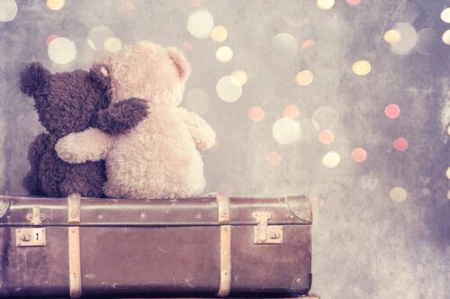 To bamser sidder på kuffert og krammer