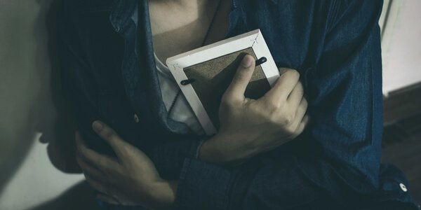 Kvinde plaget af patologisk sorg krammer billede