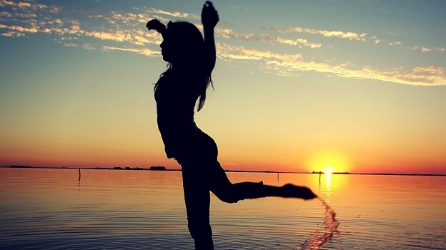 Kvinde nyder fordele ved dans foran hav