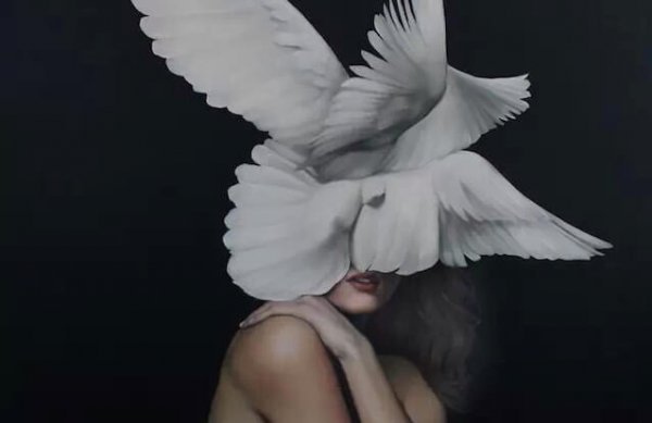 Kvinde med hvide duer foran hoved