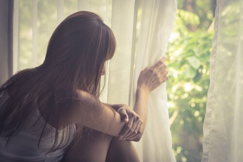 Kvinde ved vindue lider af agorafobi