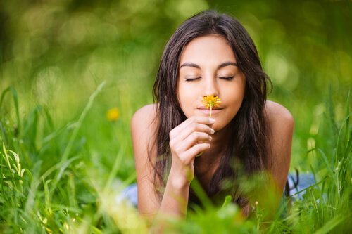 Kvinde, der dufter til blomst, formår at leve i nuet