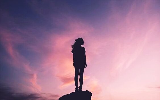 Kvinde har nået toppen af klippe på grund af positiv attitude