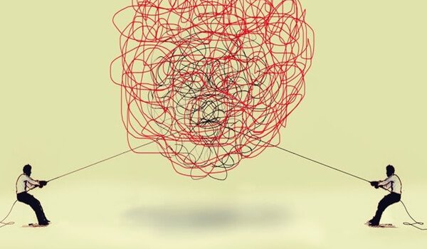 Mænd trækker i hver deres ende af kludret snor