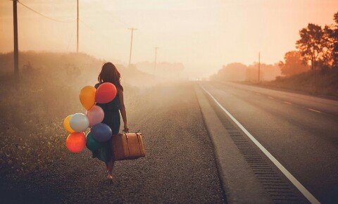 Kvinde går på vej med balloner