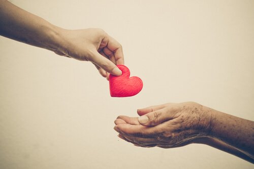 Person giver anden person hjerte som symbol på medlidenhed
