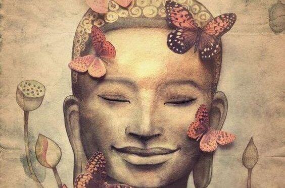 Statue af Buddha med sommerfugle belærer om buddhistisk psykologi