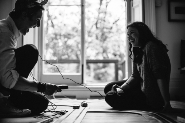 Par på gulv griner sammen