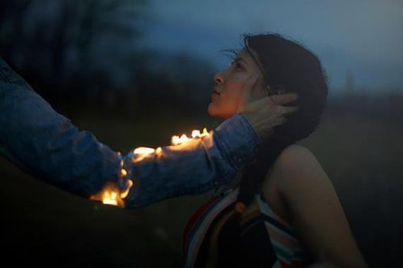 Mand med ild i arm rører kvindes ansigt