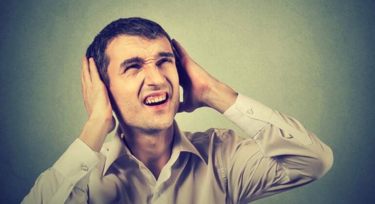 Mand med hænder for ørerne er generet af larm fra naboer