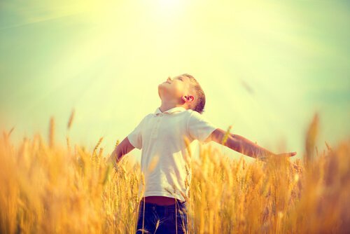 Dreng på mark kigger op mod solen
