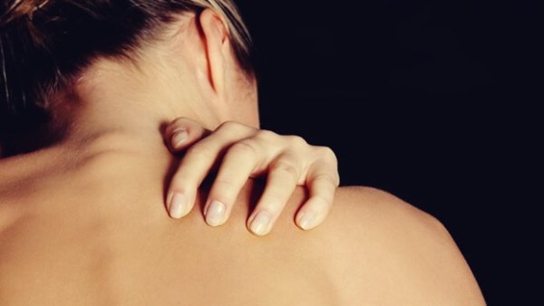 Kvinde rører ved bar skulder for at illustrere forhold mellem hud og dine følelser