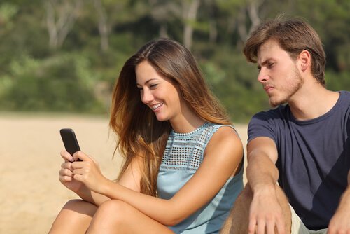 Mand tjekker kvindes sms som resultat af jalousi i et forhold