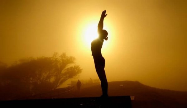Kvinde dyrker tai chi foran sol