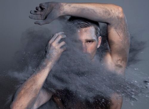 Mand med sort støv foran sig