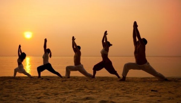 Personer dyrker tai chi på strand
