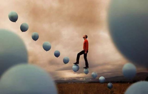 Mand går på balloner i luft