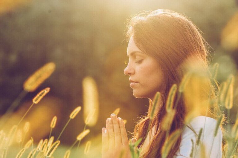Kvinde mediterer og beder om nye ting i livet