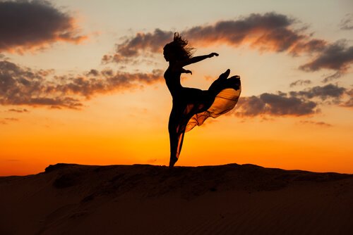 Kvinde hopper foran solnedgang som tegn på frihed