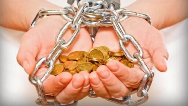 Hænder fyldt med mønter bundet i kæder