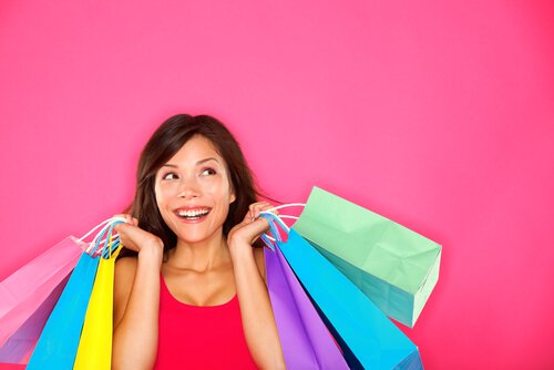 Kvinde smiler tilfreds med mange shoppingposer