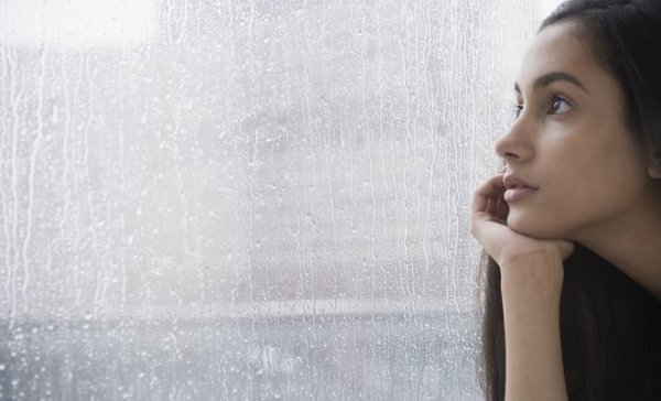 Teenager ser ud af vindue