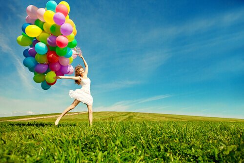 Kvinde, der hopper på mark med balloner, er eksempel på legende person