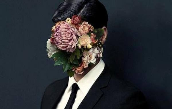 Mand med blomster foran ansigt