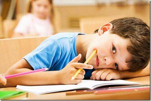 Dreng hviler hoved på bord i skole
